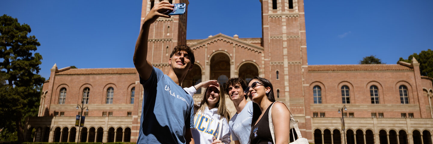 A group of students taking a selfie in front of Royce Hall.