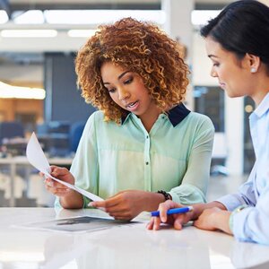two professional woman collaborting on work items